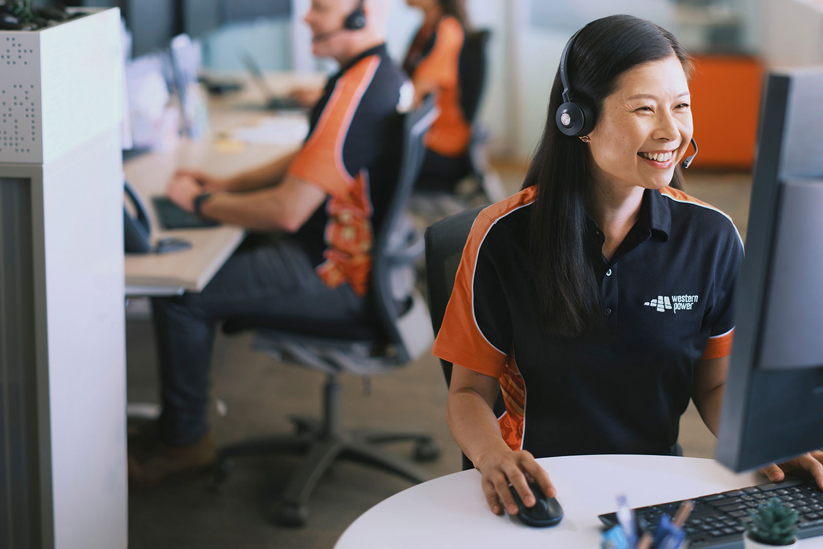 Female Western Power phone operator sat at her desk wearing a headset.