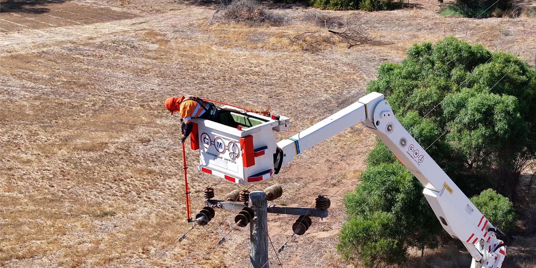 Western Power crew member in an elevated work platform siliconing a power line